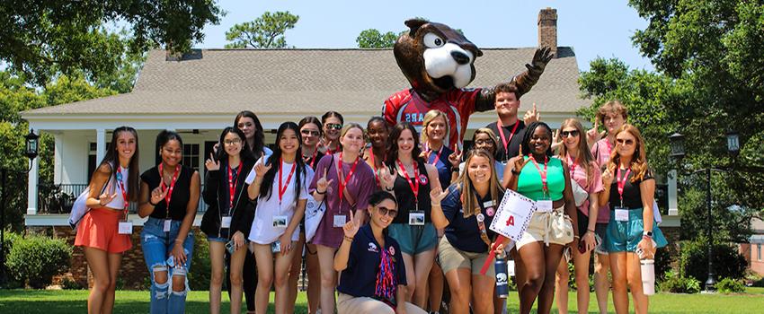 Orientation leaders with students in front of 南paw statue.